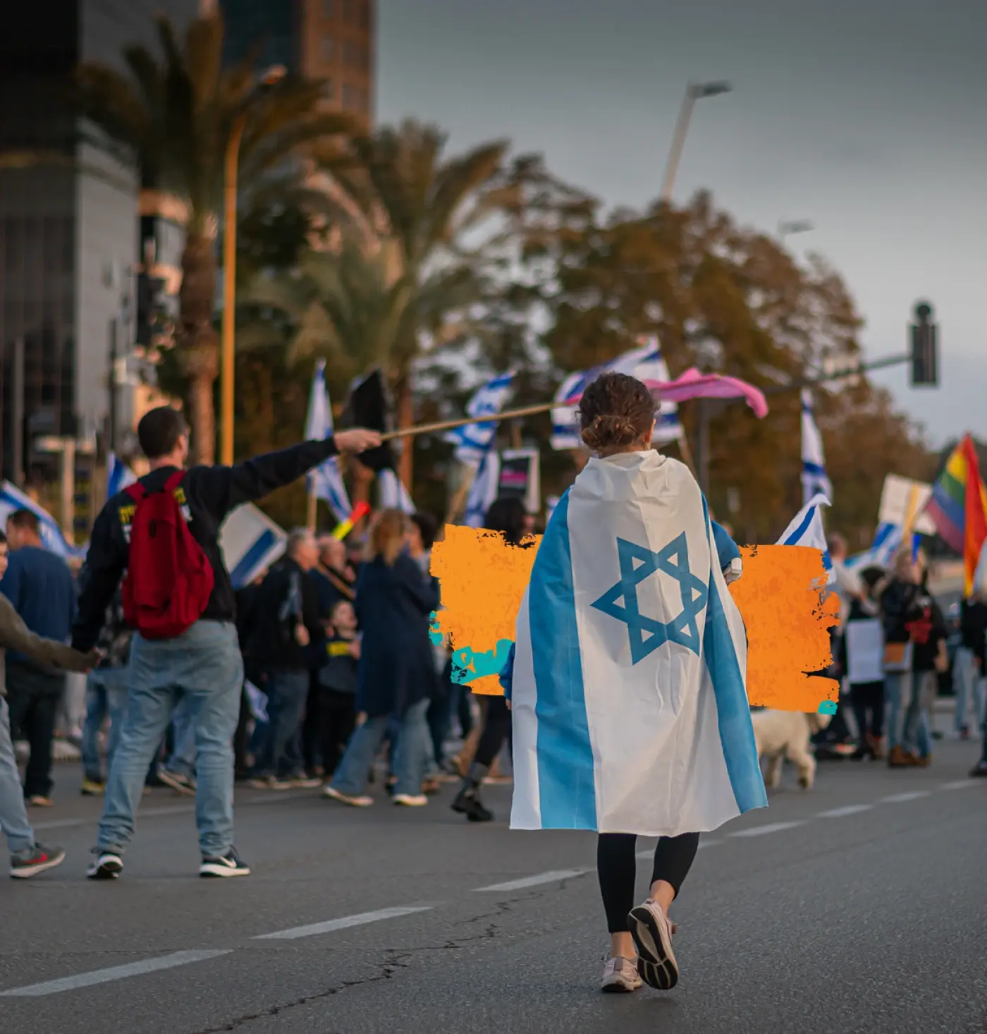 A photo of people in Tel Aviv walking down the street with an Israeli flag.