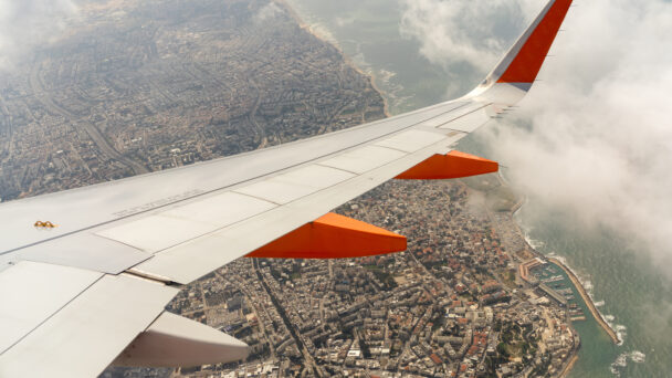 plane wing over an Israeli city, jet over a city & sea, aircraft