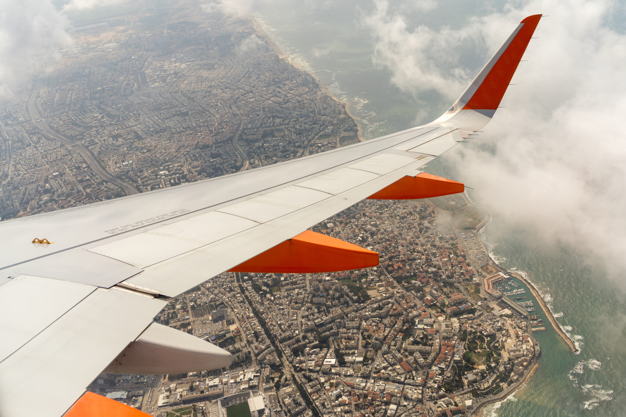 plane wing over an Israeli city, jet over a city & sea, aircraft