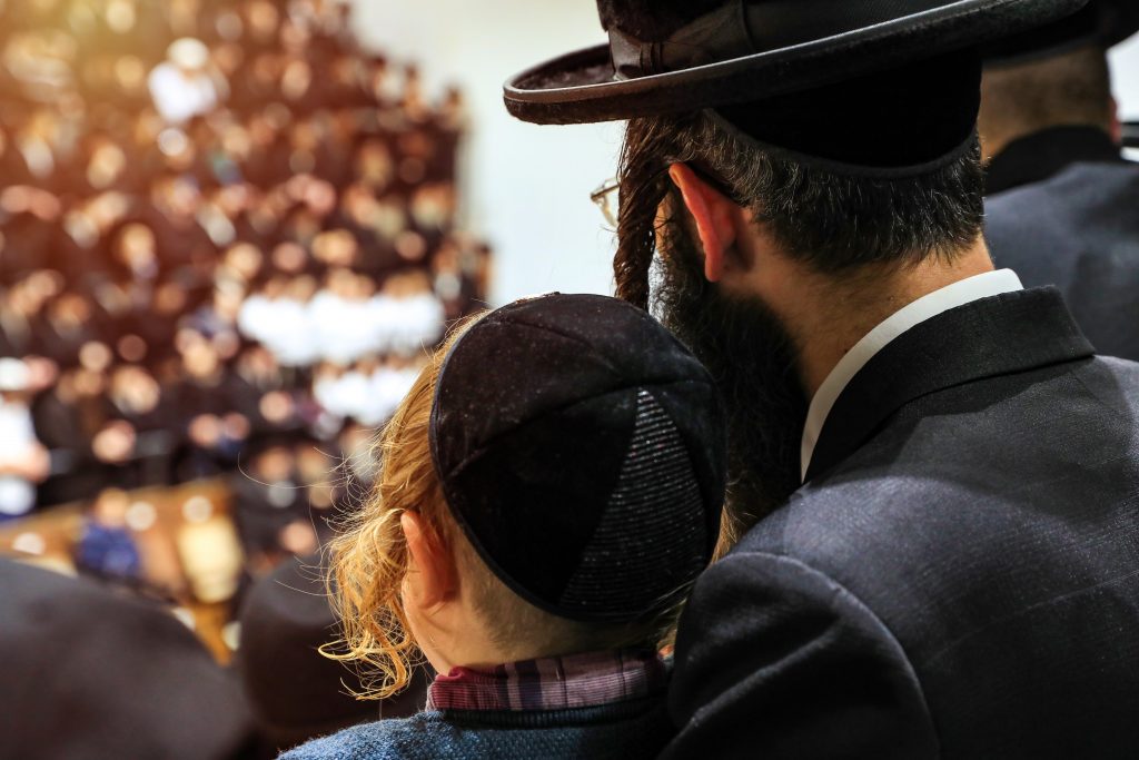 jewish man and son in a large gathering