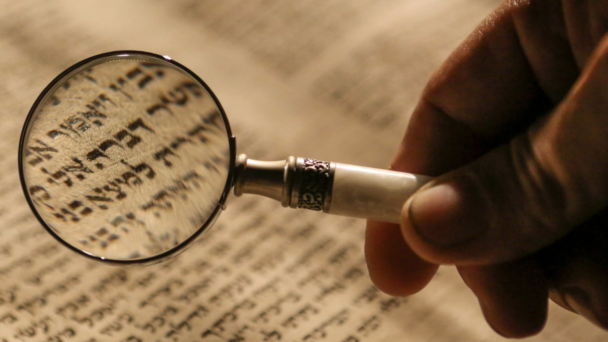 ancient hebrew text with a magnifying glass