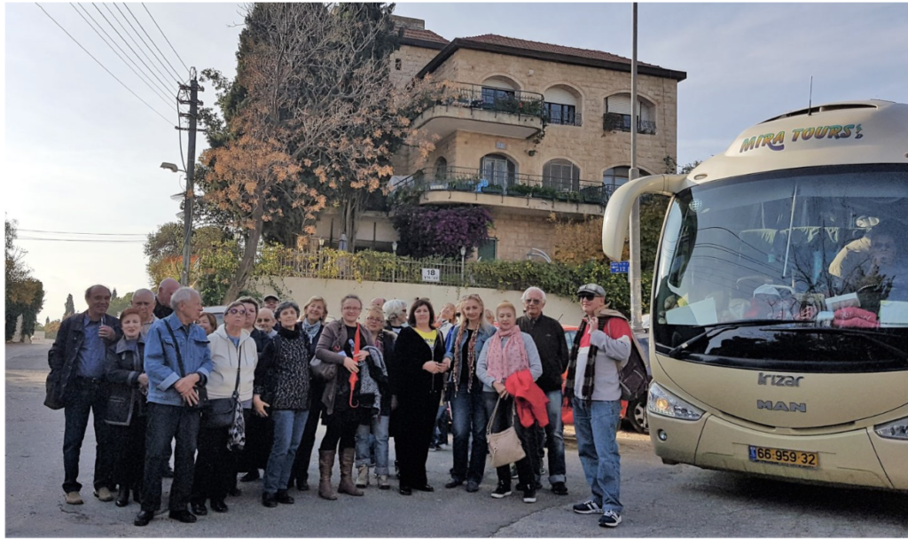 group of people in front of a tour bus