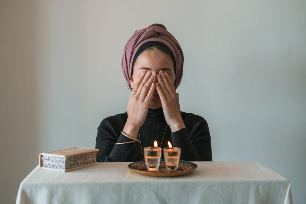 jewish woman praying over candles