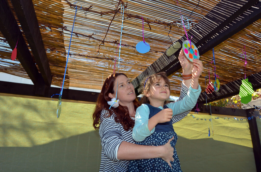 Jewish woman decorating the sukkah for the Feast of Tabernacles, one of the 3 Jewish pilgrimage holidays