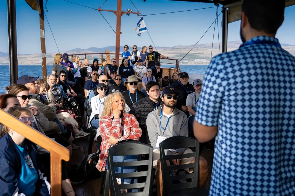 A tour group listens to a speaker on a boat 