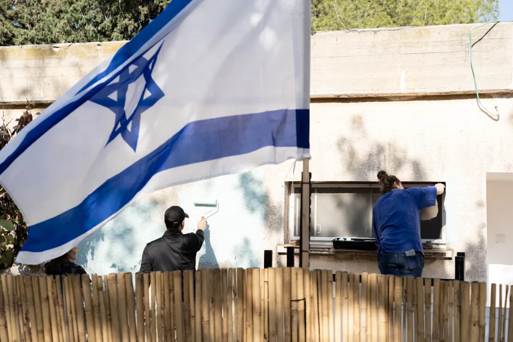 People helping paint a house in Israel
