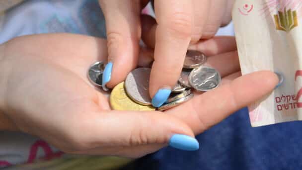 Woman holding Israeli Shekels, or ILS/NIS